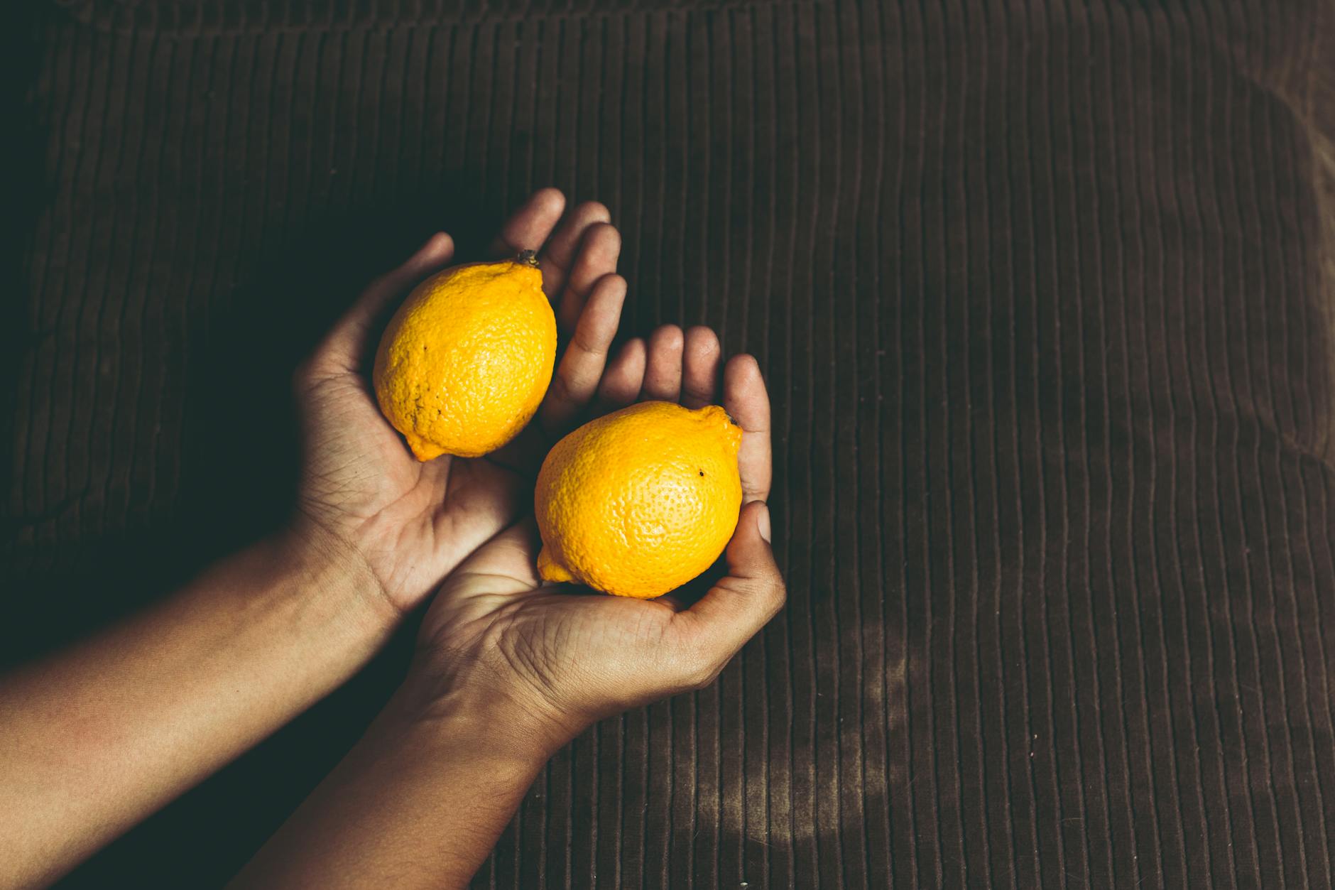 Two fresh lemons held in cupped hands, symbolizing the gentle yet powerful sensation of suction