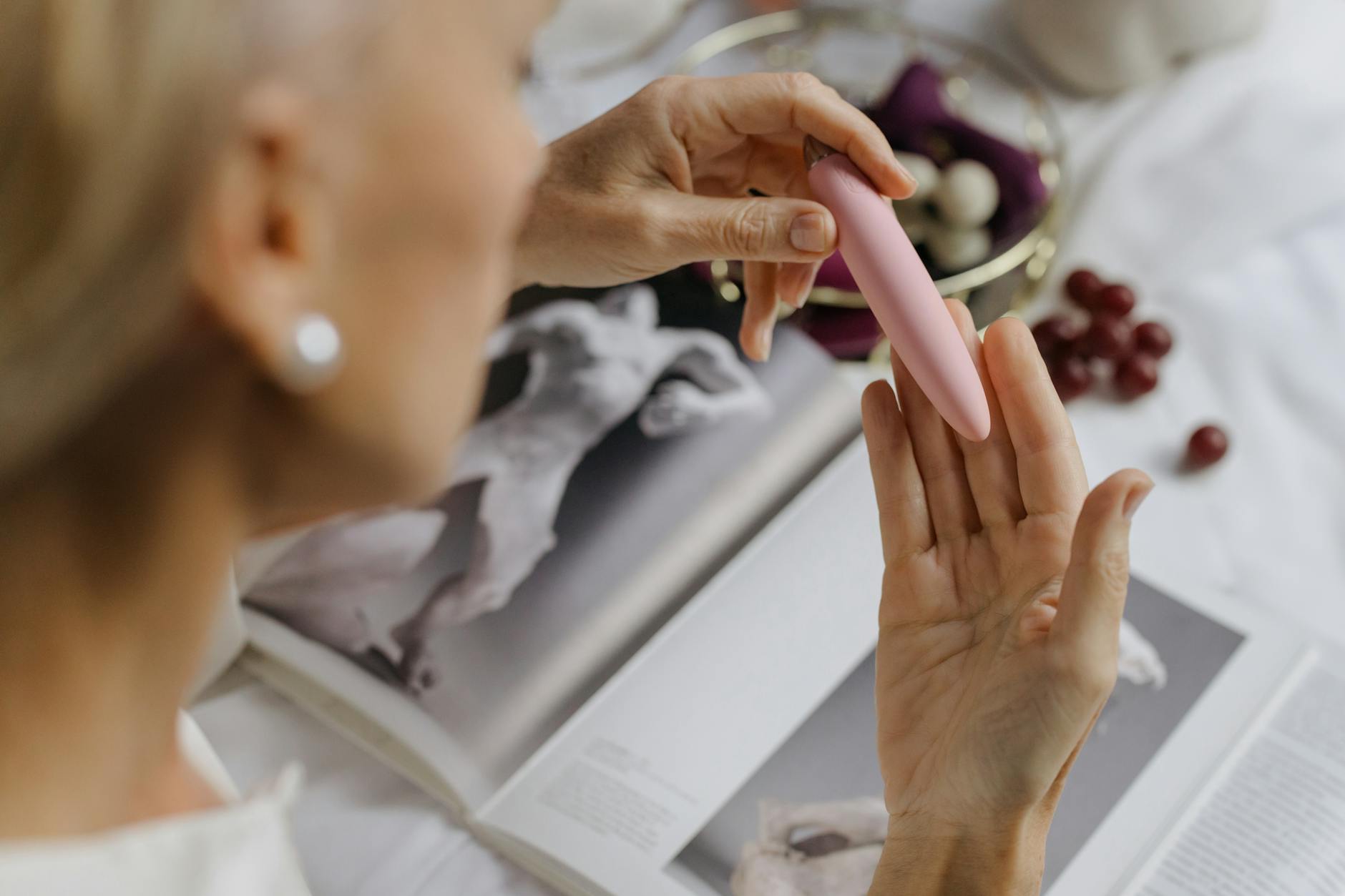 Close-up of hands holding a pink vibrator with intimacy and intention