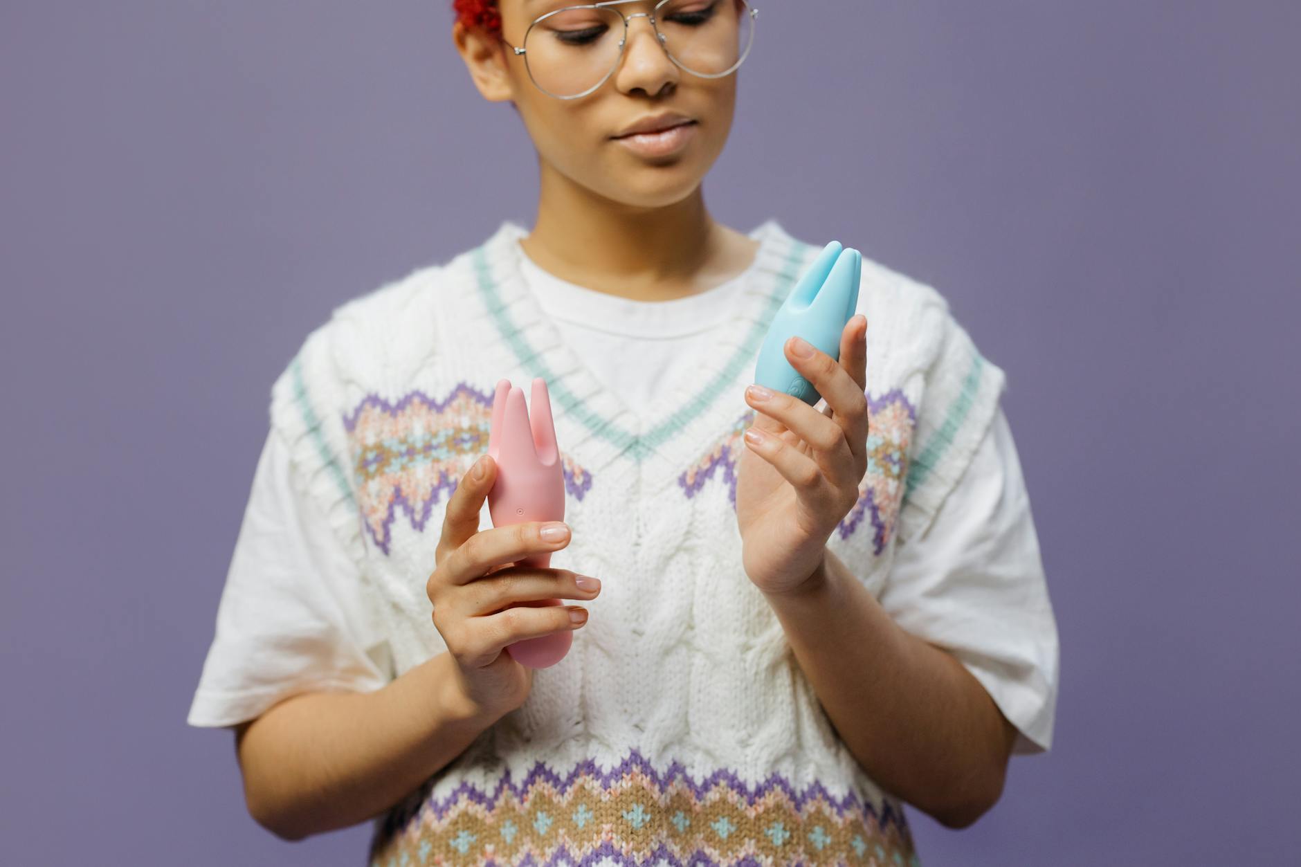 Woman holding colorful silicone vibrators and considering which toy to use