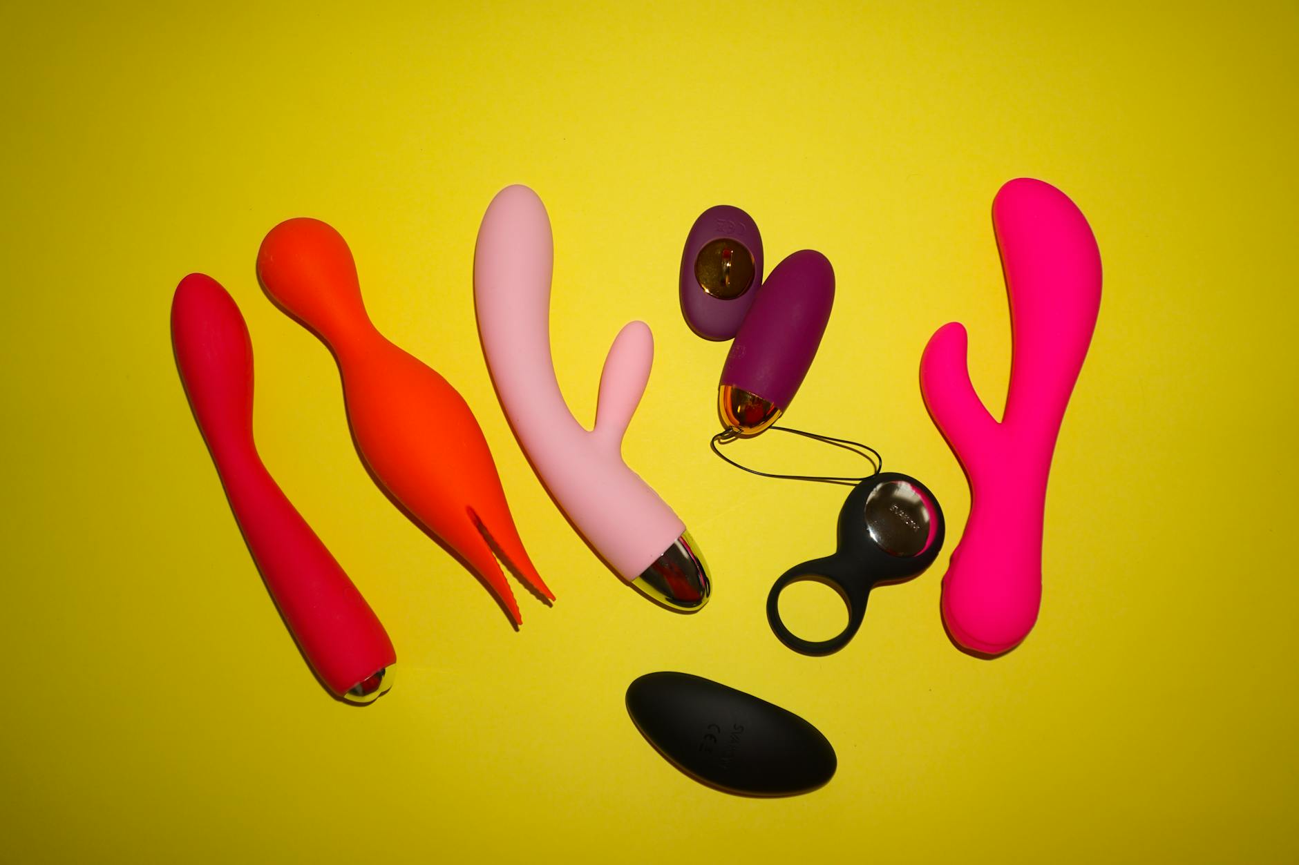 A vibrant collection of various sex toys on a black tray, featuring diverse shapes and colors.