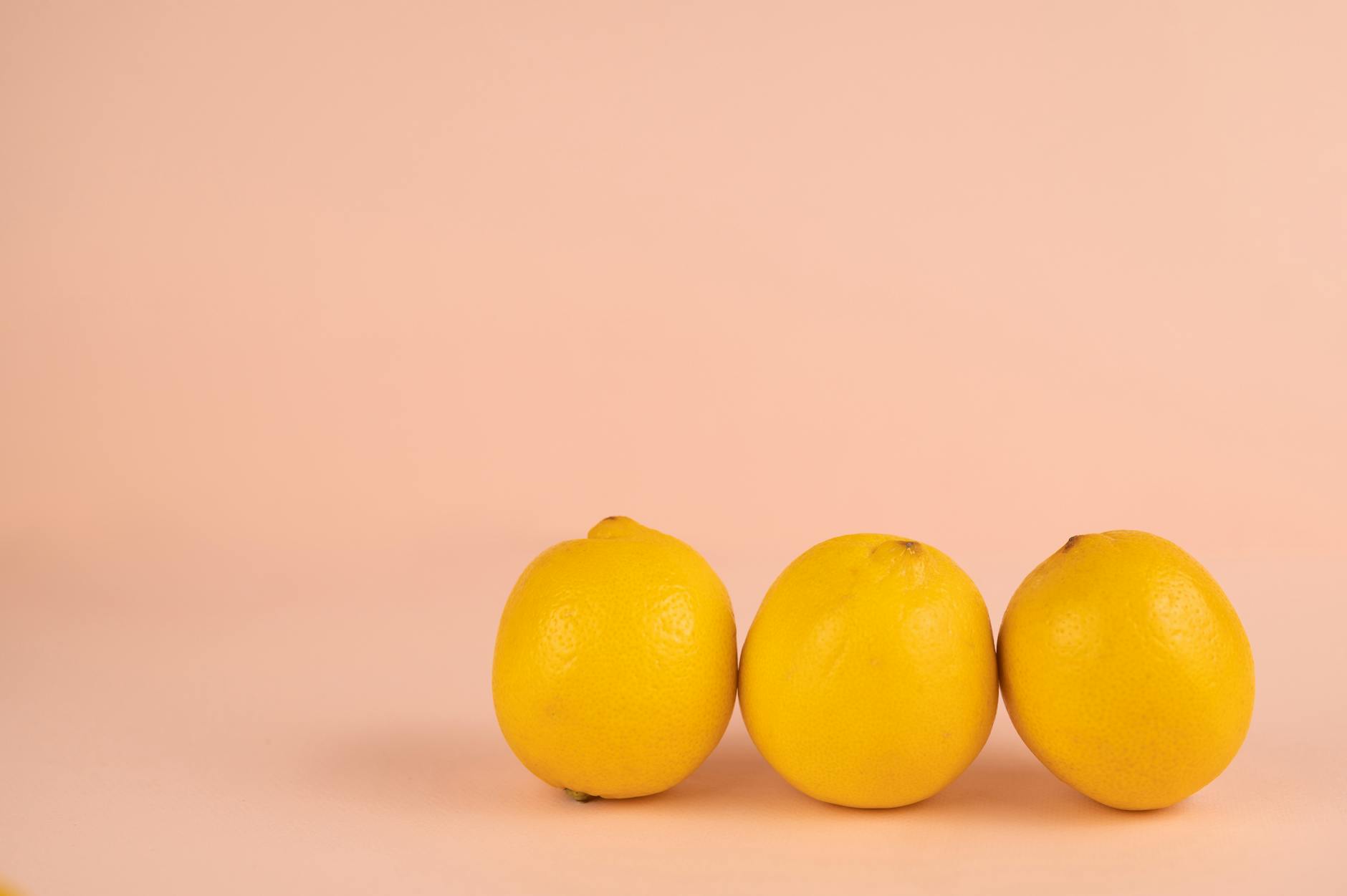Frische gelbe Zitronen auf pastellfarbenem Hintergrund, die symbolisiert wie der Lem-Vibrator neue Vitalität zurückbringt